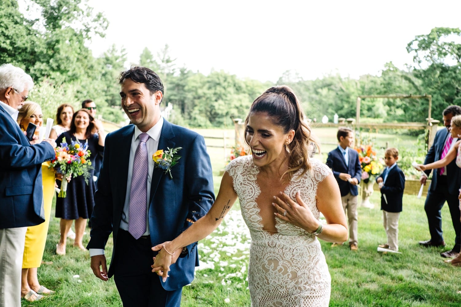 newlywed couple laughs as they walk back down the aisle after saying their vows in an intimate backyard ceremony with Kristyn Miller Photography